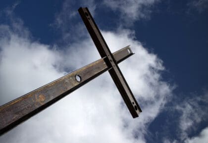 A picture of cross on a cloudy sky background. A cross that is reperesenitive of the cross that Jesus died on.